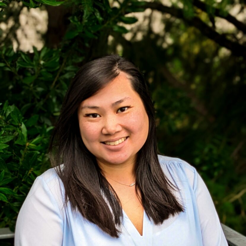 Headshot of woman smiling in front of trees