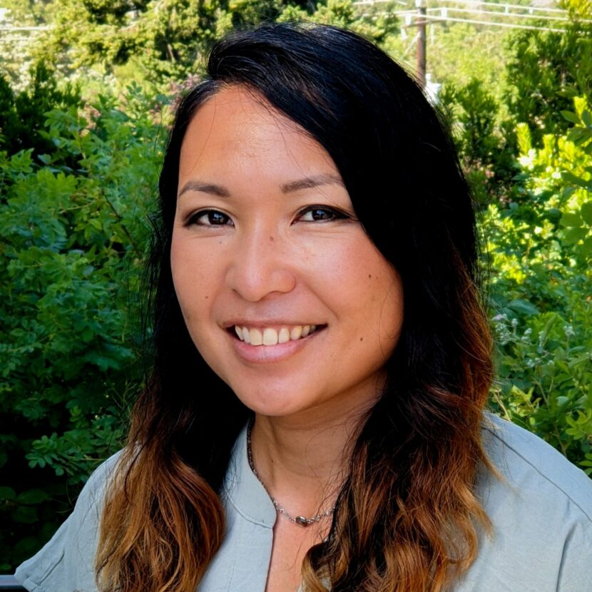 Headshot of woman smiling in front of trees