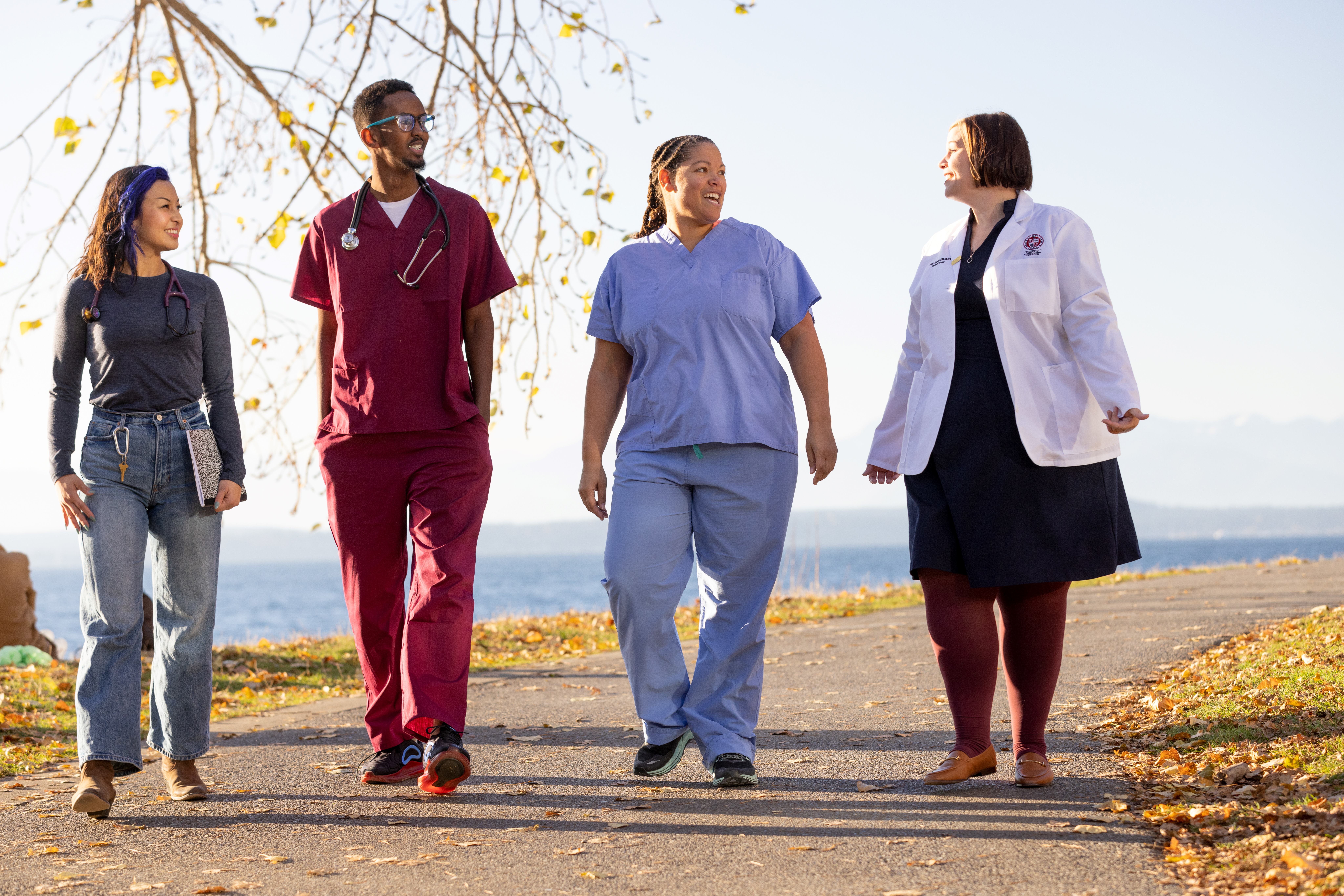 Four nursing Scholars walking on a path by the water