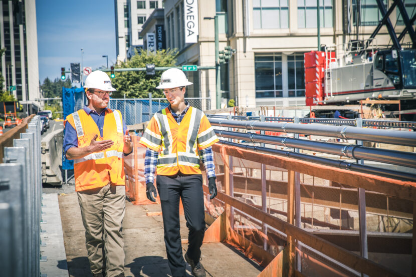 Two people walking through a construction site
