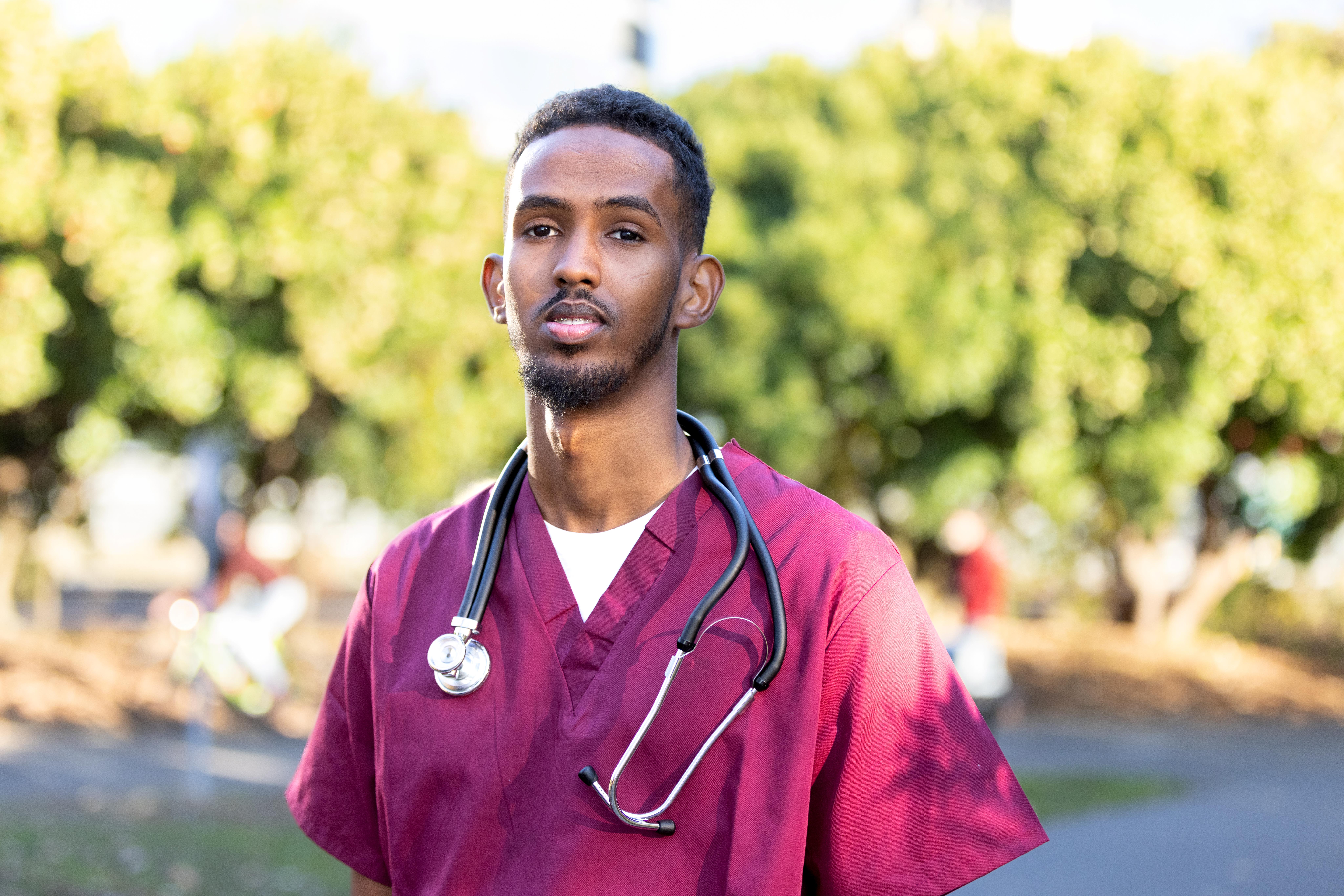 Opportunity Scholar standing in scrubs with a stethoscope around his neck