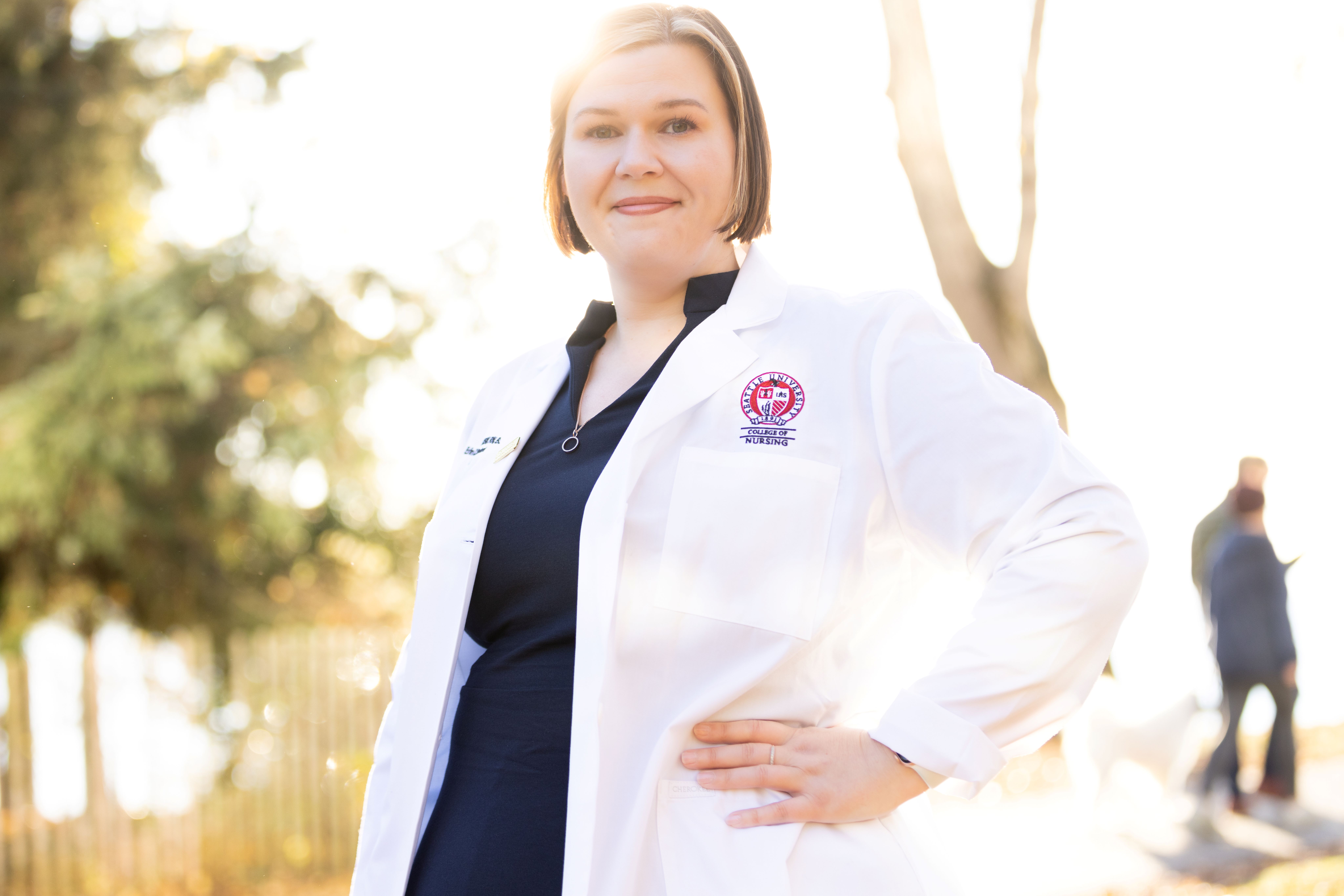 Advanced health care graduate scholar posing confidently in white coat