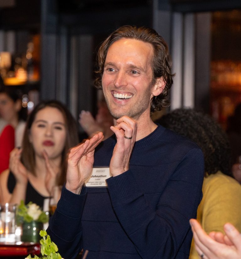 Johnathan, Programs Director, clapping at an event