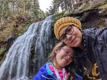 Veronica and her daughter standing in front of waterfalls