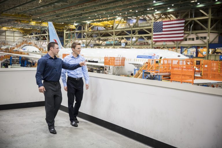 Two people walking through a Boeing warehouse