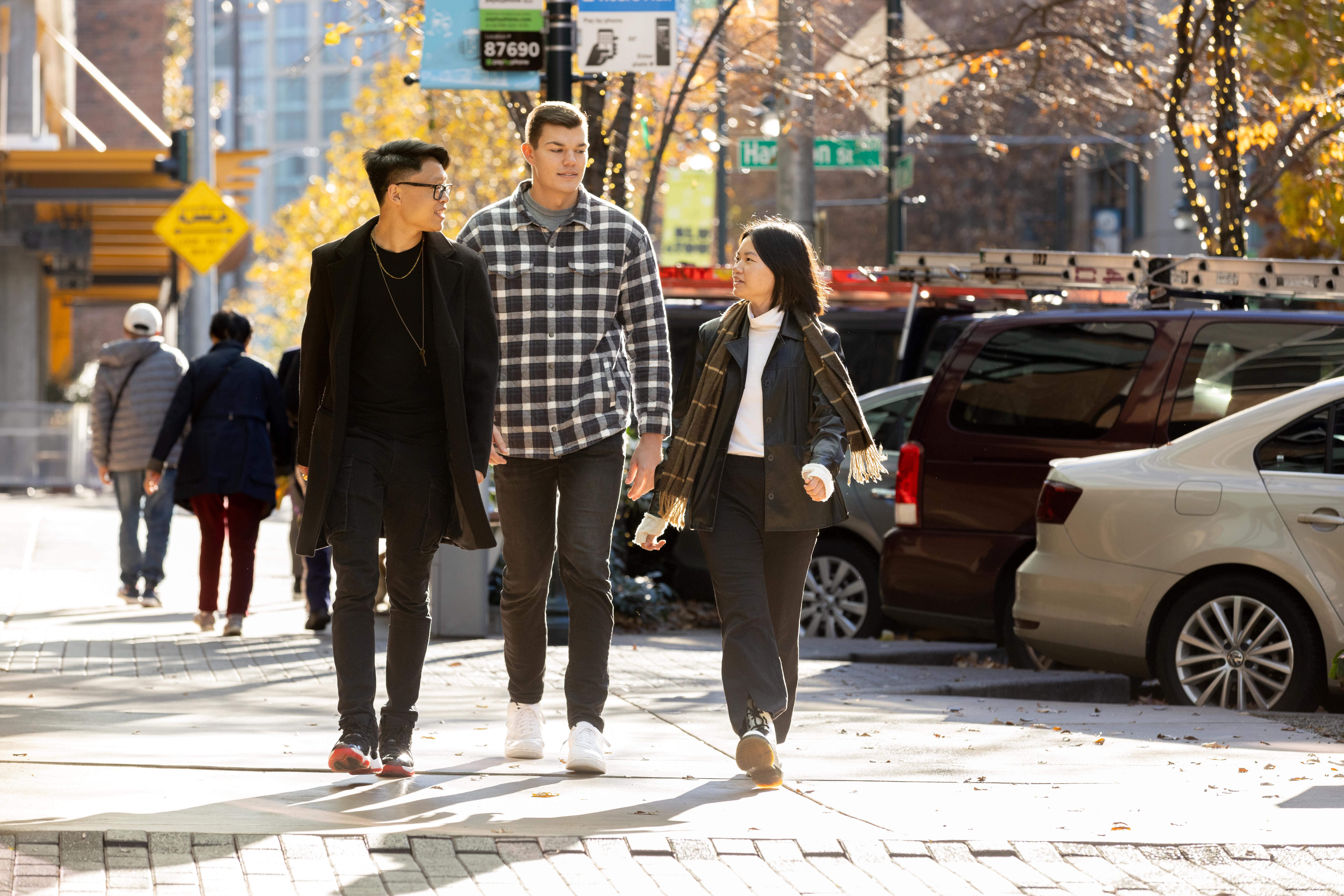Opportunity Scholars Jonathan, Dylan, & Nancy walking down a city street